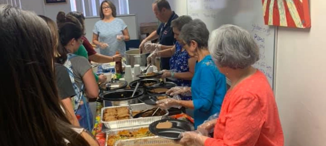 AROMAS Abuelitas and volunteers serving food to students